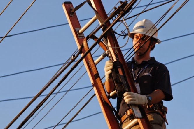 Imagem de um técnico de telefonia subindo em um poste