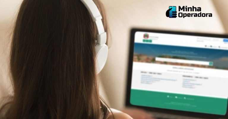 Menina de frente para o notebook e utilizando um headphone.