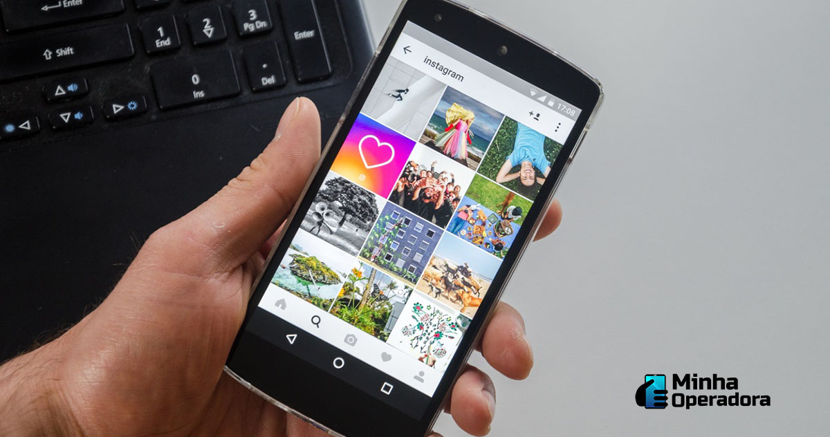 Smartphone com navegação no Instagram em tela.