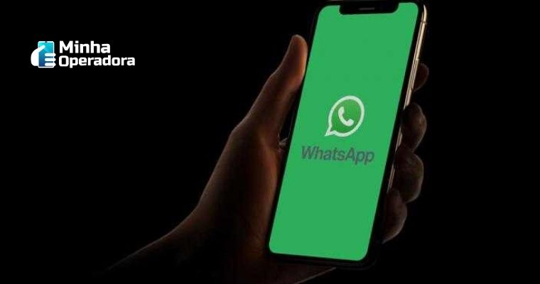 Mão segurando um celular com o aplicativo do WhatsApp aberto.