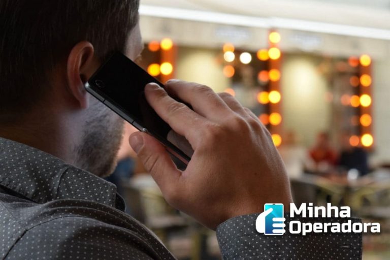 Homem atendendo telefone celular na rua