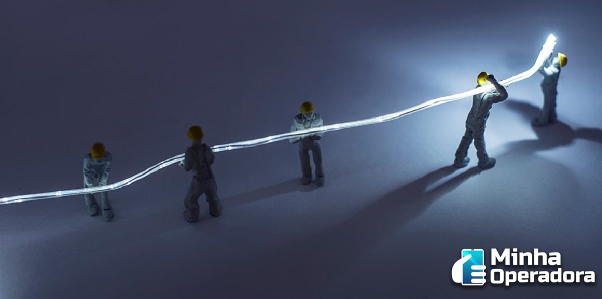 Homens segurando cabo de fibra ótica